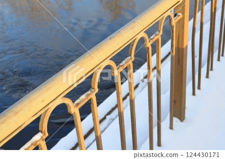 Golden Railing Set Against Calm Waters in a Serene Winter Landscape and Setting Atmosphere Golden Railing Set Against Calm Waters in a Serene Winter Landscape and Setting Atmosphere 124430171