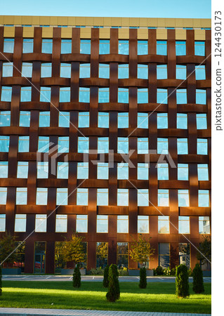 A modern architectural facade with reflective windows that enhances its urban aesthetic A modern architectural facade with reflective windows that enhances its urban aesthetic 124430173