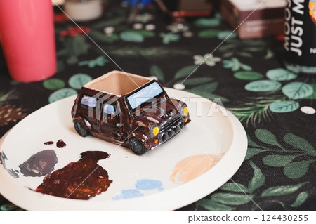 A vibrant and colorful miniature car craft beautifully displayed on an artistic plate 124430255