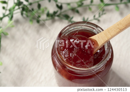 Lifting a spoonful of strawberry jam from a jar Lifting a spoonful of strawberry jam from a jar 124430513