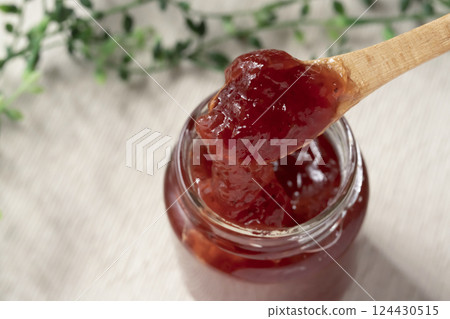 Lifting a spoonful of strawberry jam from a jar Lifting a spoonful of strawberry jam from a jar 124430515