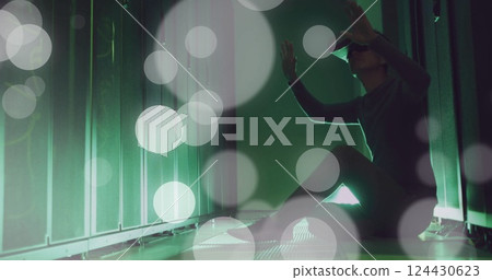 Image of spots of light and data processing over asian man using vr headset by computer servers 124430623