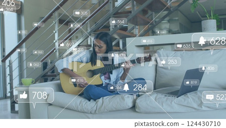 Image of icons and data processing over biracial woman playing guitar 124430710