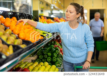 woman buys juicy tangerines in supermarket 124431649