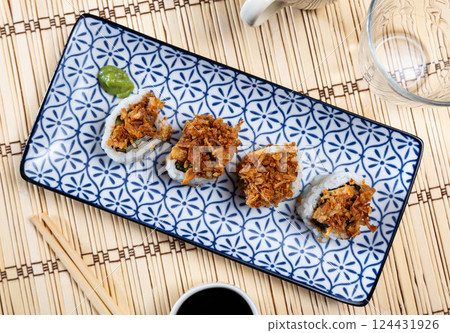 Plate is filled with crunch California rolls with fried puffed rice Plate is filled with crunch California rolls with fried puffed rice 124431926
