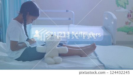 Sitting on hospital bed with tablet, girl gaining followers over image Sitting on hospital bed with tablet, girl gaining followers over image 124432245