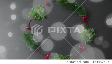 Christmas wreath with red berries and green pine branches over bokeh lights image 124432303