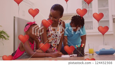 Red heart balloons image over family drawing together in kitchen 124432308