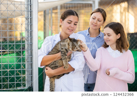 Female animal shelter worker offering gray cat for adoption Female animal shelter worker offering gray cat for adoption 124432366