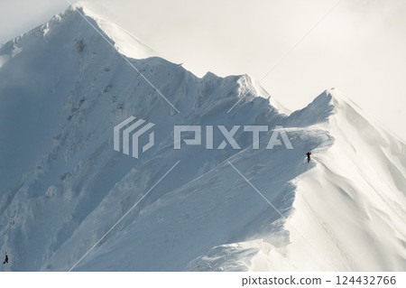雪煙飄落在山腰；陡峭的雪山山脊；三月爬雪山 124432766