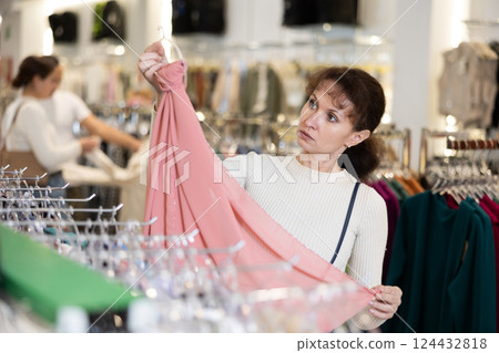 Adult woman choosing scarf in store 124432818