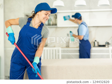 Cleaning lady washes kitchen floor in client house until it shines 124432820