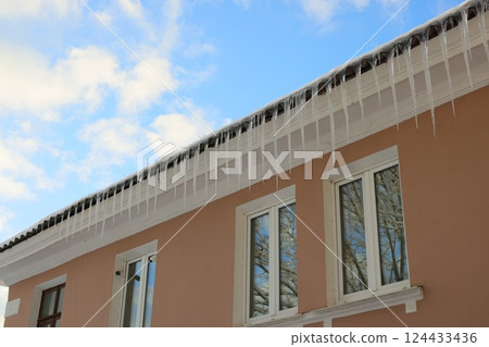 Stunning Icicles Gracefully Hanging from Roof Beneath a Clear and Beautiful Blue Sky Stunning Icicles Gracefully Hanging from Roof Beneath a Clear and Beautiful Blue Sky 124433436