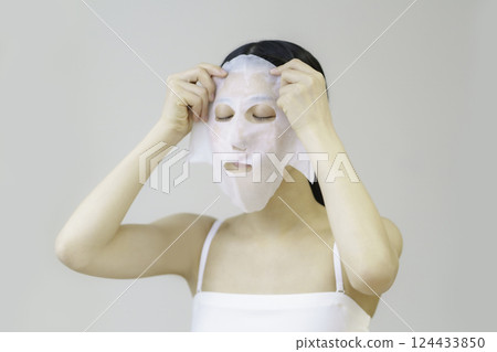Young woman applying sheet mask 124433850