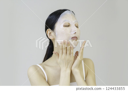 Young woman applying sheet mask 124433855