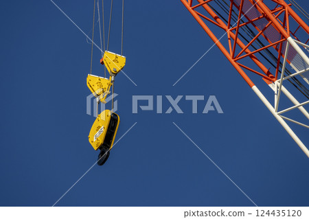 Close-up of a climbing crane hook. Image of a construction site Close-up of a climbing crane hook. Image of a construction site 124435120