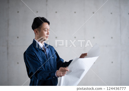 Architects and construction managers looking at blueprints Architects and construction managers looking at blueprints 124436777