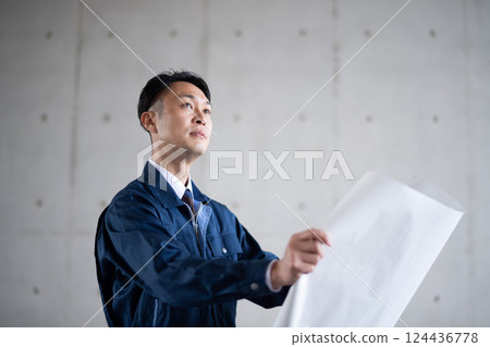 Architects and construction managers looking at blueprints Architects and construction managers looking at blueprints 124436778