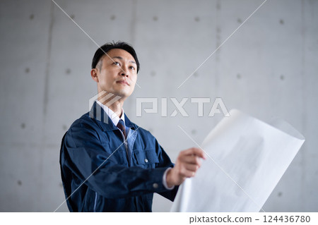 Architects and construction managers looking at blueprints 124436780