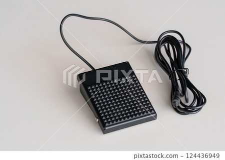 Black Electrical Foot Pedal Switch with Textured Surface and Long Cable on White Background Black Electrical Foot Pedal Switch with Textured Surface and Long Cable on White Background 124436949