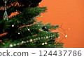 Close-up of artificial Christmas tree branch. Sparkling garlands with miniature LEDs softly illuminate fluffy green branches. New Year. Christmas. Christmas tree in the office. Place for your text. 124437786