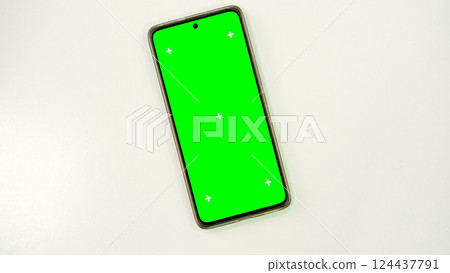 Mobile phone with green screen lies on white surface. Mobile phone mockup. Social media advertising concept, trading platforms. Smartphone with chromakey. Close-up. Plenty of space for your text. Mobile phone with green screen lies on white surface. Mobile phone mockup. Social media advertising concept, trading platforms. Smartphone with chromakey. Close-up. Plenty of space for your text. 124437791
