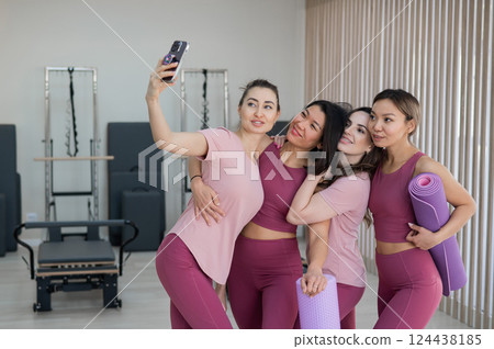 Two Caucasian and two Asian women take a selfie after a Pilates workout.  124438185