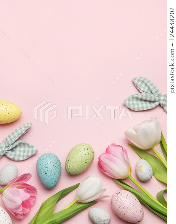 Easter eggs and tulips creating a frame on pink background 124438202