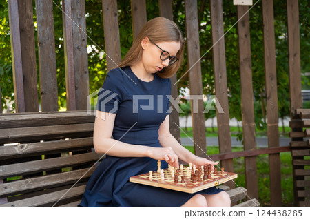 Caucasian woman playing chess outdoors. 124438285