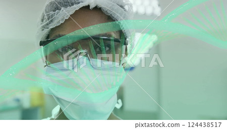 Image of dna strand rotating over portrait of african american female surgeon in theatre Image of dna strand rotating over portrait of african american female surgeon in theatre 124438517