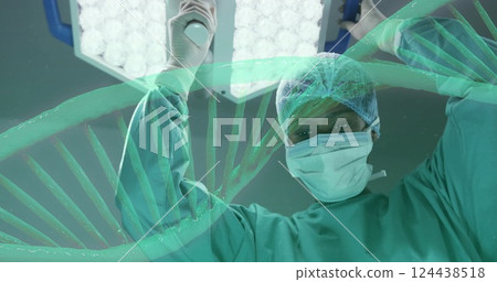 Image of dna strand rotating over african american female surgeon working in theatre Image of dna strand rotating over african american female surgeon working in theatre 124438518