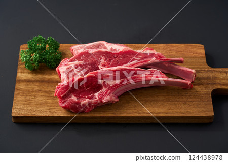 Raw lamb chops on a wooden cutting board 124438978