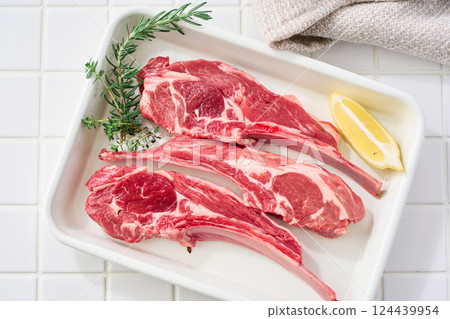 Raw lamb chops arranged on a white tray Raw lamb chops arranged on a white tray 124439954