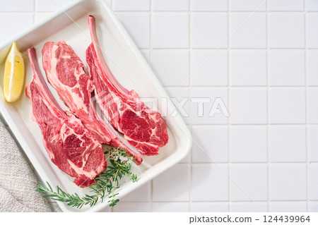 Raw lamb chops arranged on a white tray 124439964