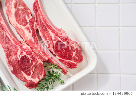 Raw lamb chops arranged on a white tray Raw lamb chops arranged on a white tray 124439965
