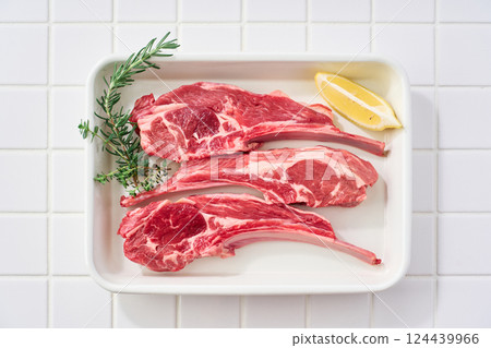 Raw lamb chops arranged on a white tray Raw lamb chops arranged on a white tray 124439966