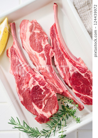 Raw lamb chops arranged on a white tray 124439972