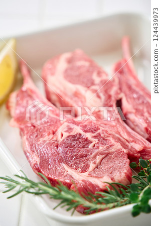Raw lamb chops arranged on a white tray 124439973