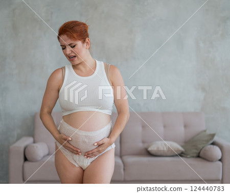 Caucasian pregnant woman in adult diapers suffers from incontinence. Caucasian pregnant woman in adult diapers suffers from incontinence. 124440783