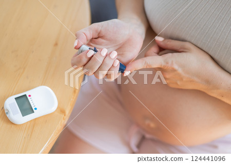 Pregnant woman doing home blood sugar test. Gestational diabetes. Pregnant woman doing home blood sugar test. Gestational diabetes. 124441096