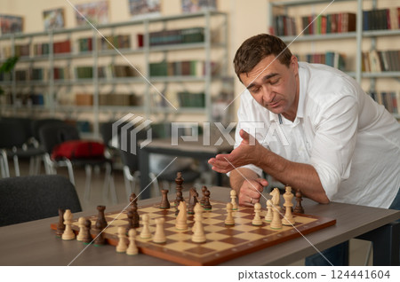 Caucasian man thinking about a chess move. Caucasian man thinking about a chess move. 124441604