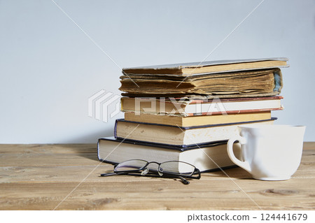 stack of books with a cup and glasses next to it. Space for text. The concept of training and education. 124441679