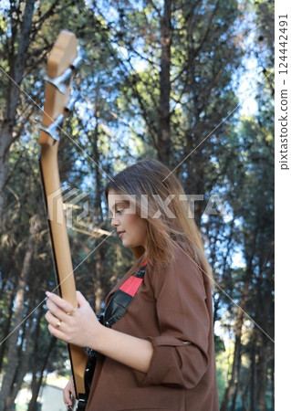 Young Girl Plays Bass Musical Instrument Under Trees In Nature 124442491
