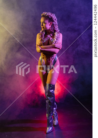 Woman showcases artistic body art with silver tape in lingerie at vibrant event Woman showcases artistic body art with silver tape in lingerie at vibrant event 124442496