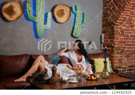 Elegant woman posing in lingerie on a cozy couch in a stylish setting Elegant woman posing in lingerie on a cozy couch in a stylish setting 124442505