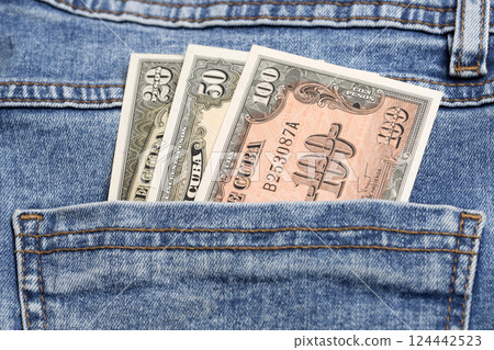 Old Cuban pesos in the pocket of blue jeans 124442523