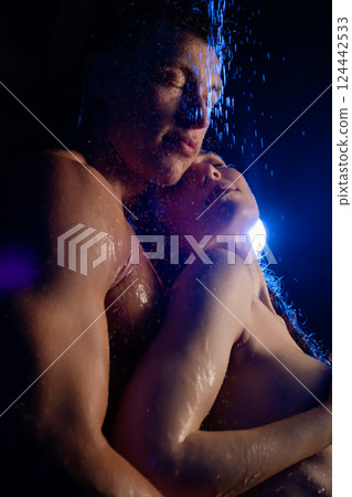 Embracing under soft light and cascading water in an intimate moment Embracing under soft light and cascading water in an intimate moment 124442533