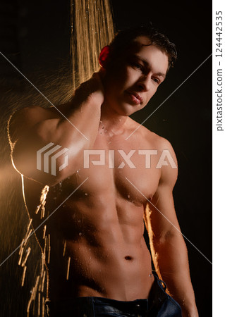 Man enjoying a warm shower while water cascades over his body 124442535