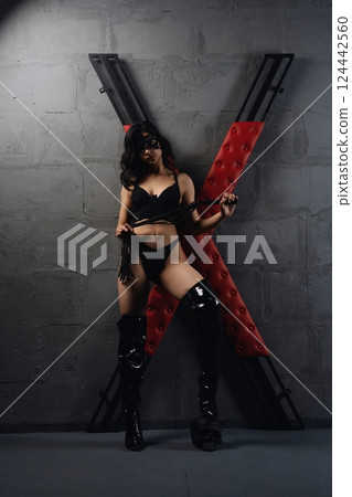 Woman Posing With Whip and X-Frame Cross prepared for sexual bdsm game 124442560