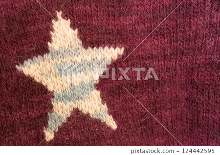 knitted texture, burgundy sweater, or carpet with stars. industrial knitting of clothes made wool. 124442595